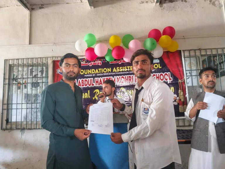 Student receiving a result card at the prize distribution