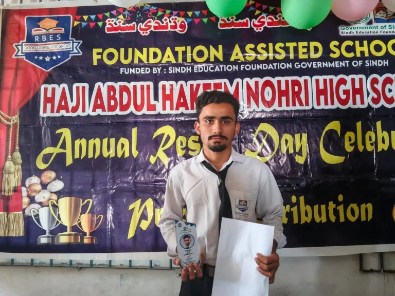 Student holding his shield and result card