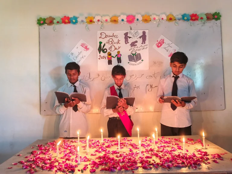 Boys reading from books at the 16 December remembrance ceremony