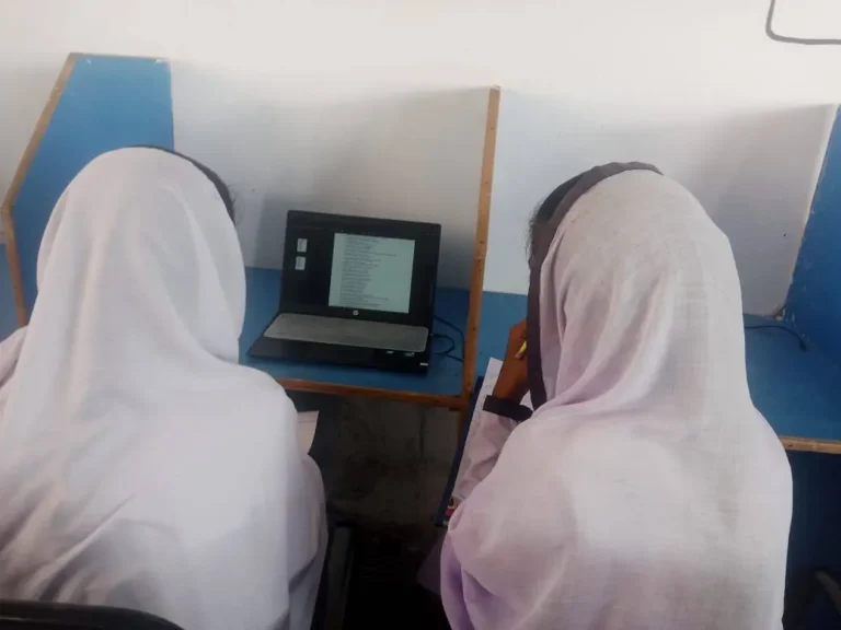 Two Class 10 students working on a chemistry MCQ test on a laptop