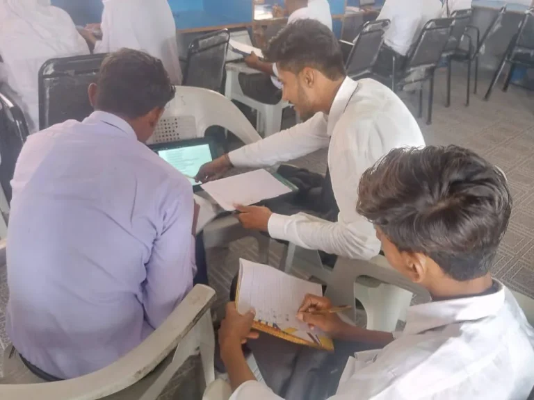 Boys working together at laptops during the Class 10 chemistry test