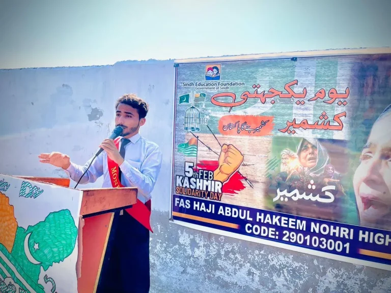 Student gesturing while addressing classmates on Kashmir Solidarity Day