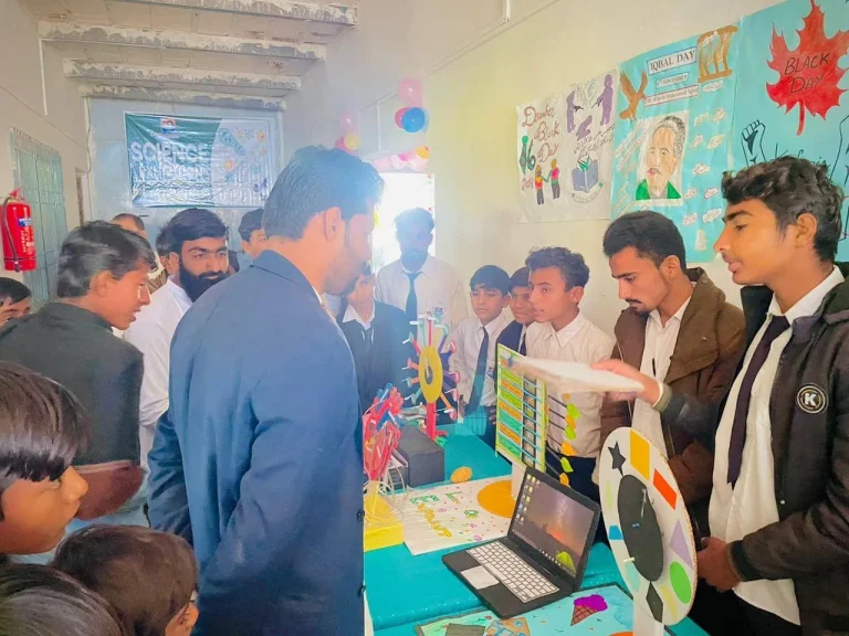 Students presenting a project with a laptop to visitors