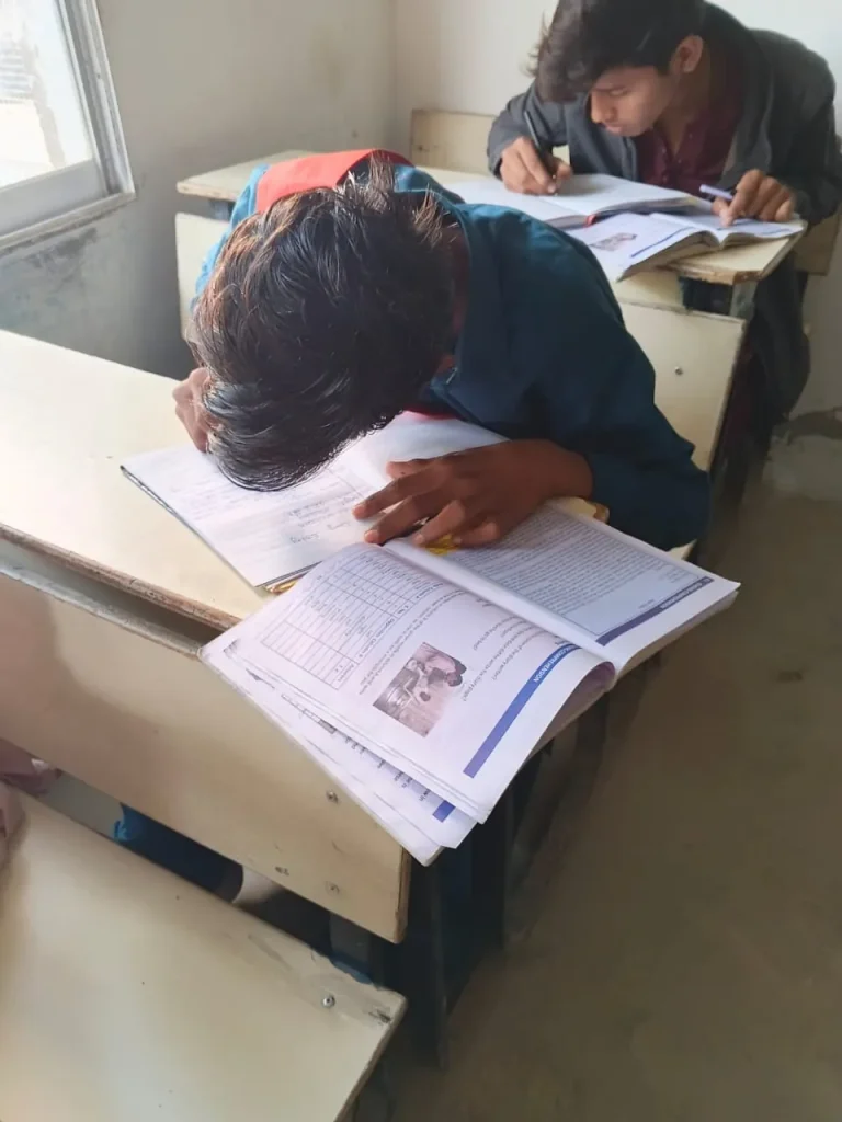 Student bent over his notebook writing during the writing competition